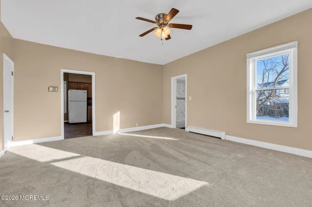 a view of a bedroom with a ceiling fan and a window