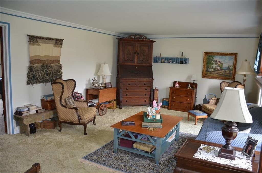 8187 Post Road Allison Park, PA 15101 - Photo 3 of 24 As you enter the home the living room is on the right. There is never exposed hard wood under the carpet and crown moulding trim around the ceiling. Also plenty of natural light thru the Pella windows.