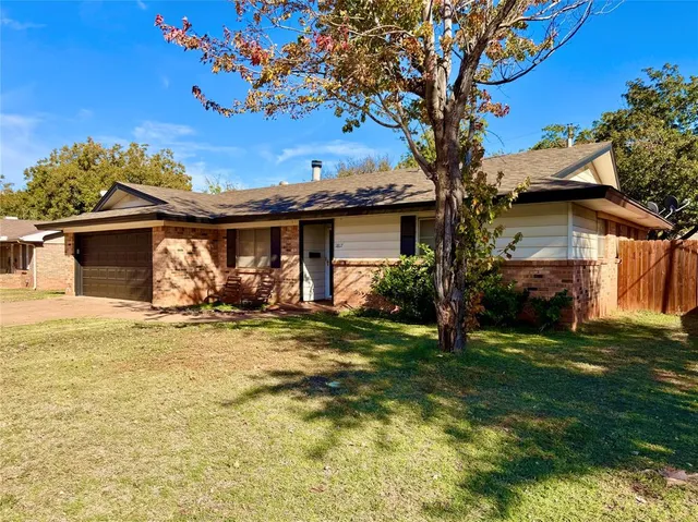 a view of a house with backyard and a tree