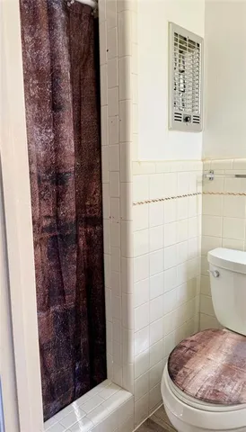 a bathroom with a toilet and a shower