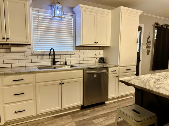 a kitchen with granite countertop cabinets stainless steel appliances and a sink