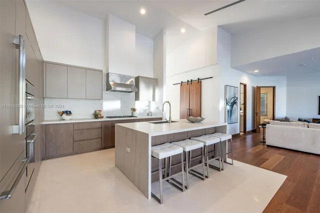 a living room with stainless steel appliances kitchen island hardwood floor and a view of kitchen