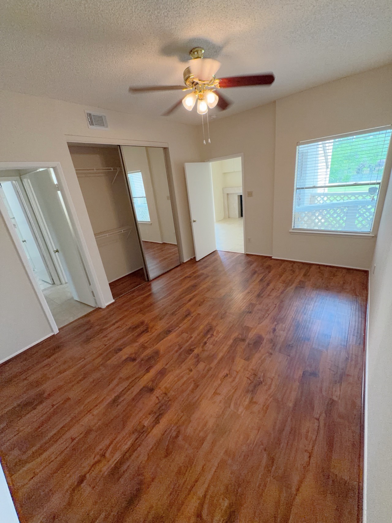 7900 Bissonnet Street, Unit C14 Houston, TX 77074 - Photo 7 of 14 a view of an empty room with wooden floor and a window