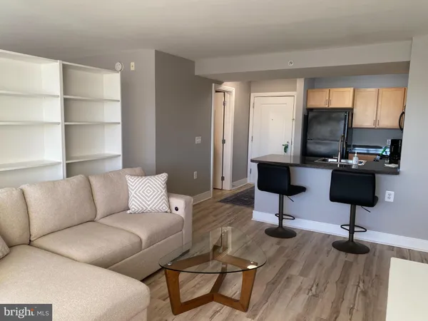 a living room with furniture a desk and chair with wooden floor