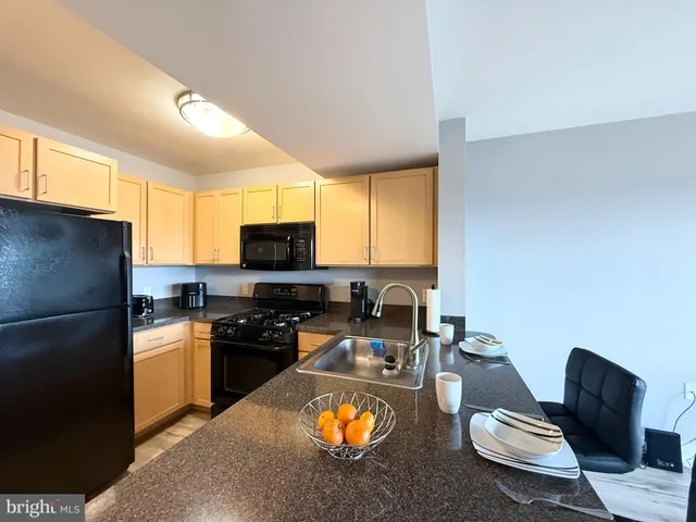 a kitchen with stainless steel appliances granite countertop a stove refrigerator and a microwave