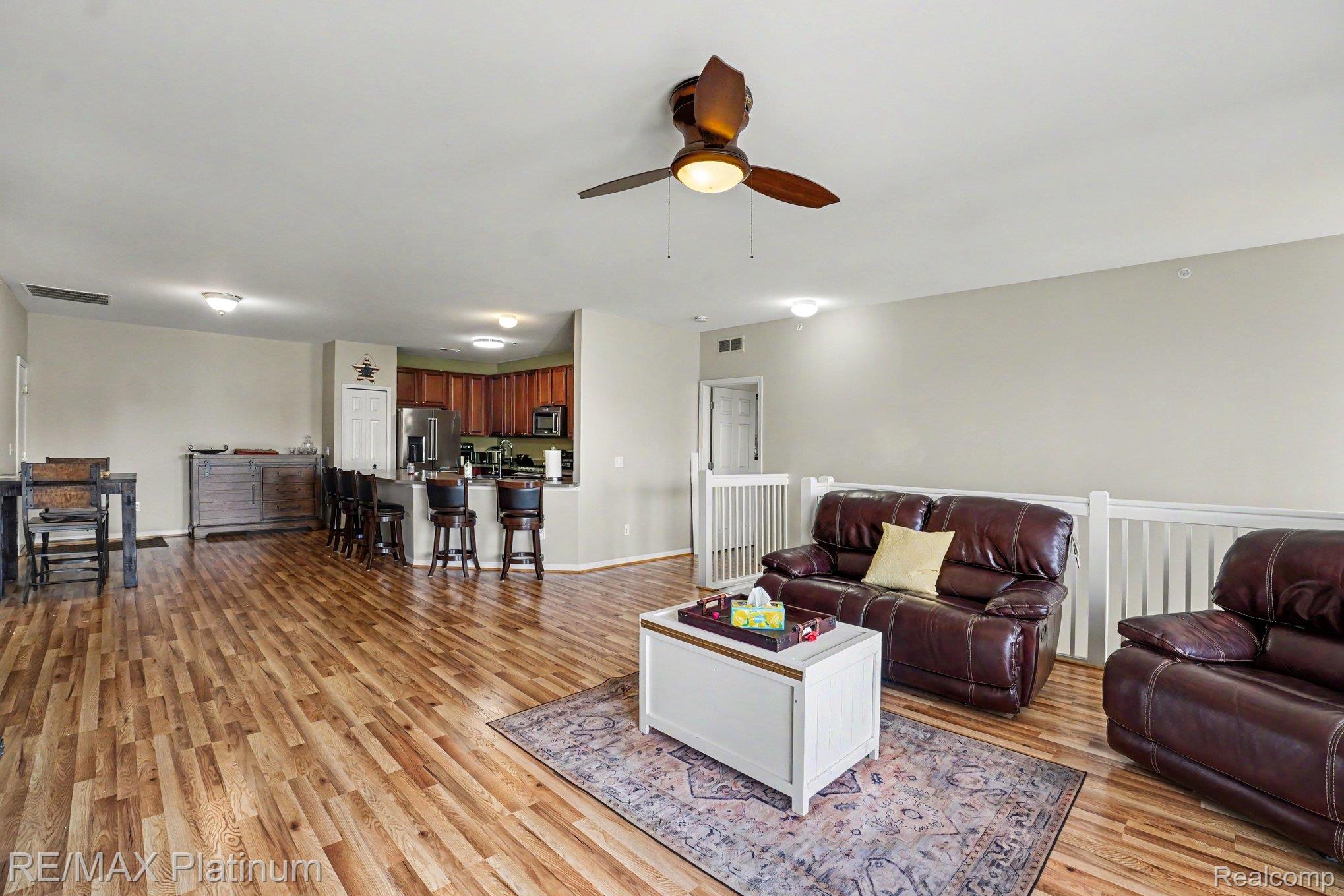 10217 Crossview Trail Howell, MI 48855 - Photo 8 of 26 Spacious open-concept living area featuring wood-finish flooring, a ceiling fan with integrated lighting, and neutral wall tones