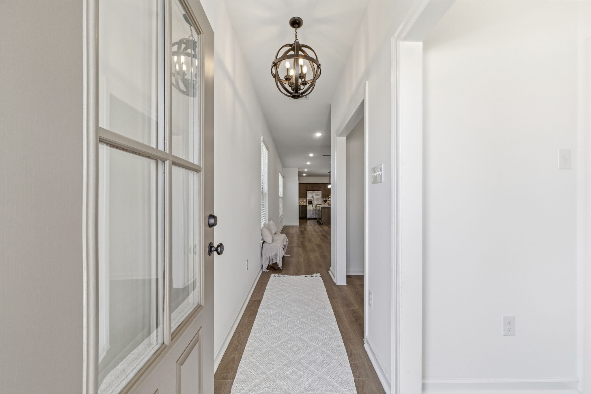 10934 Bonfire Trail Beasley, TX 77417 - Photo 3 of 32 Step inside to a welcoming foyer featuring luxury vinyl plank flooring, soaring ceilings, elegant designer lighting, and a versatile flex space just off the entry—perfect for a home office, formal dining room, or playroom.