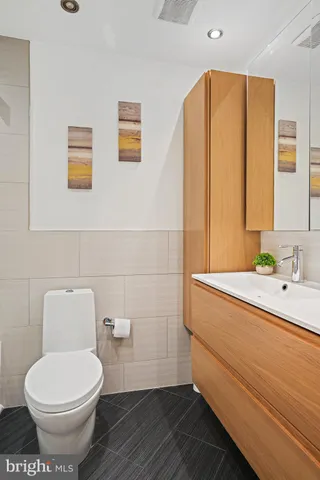 a bathroom with a toilet a sink and mirror