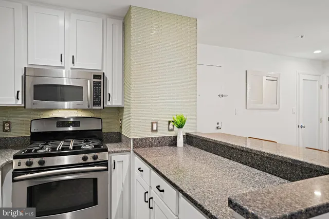 a kitchen with granite countertop a stove and a sink