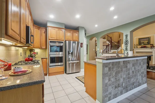 a kitchen with stainless steel appliances granite countertop a refrigerator and a stove