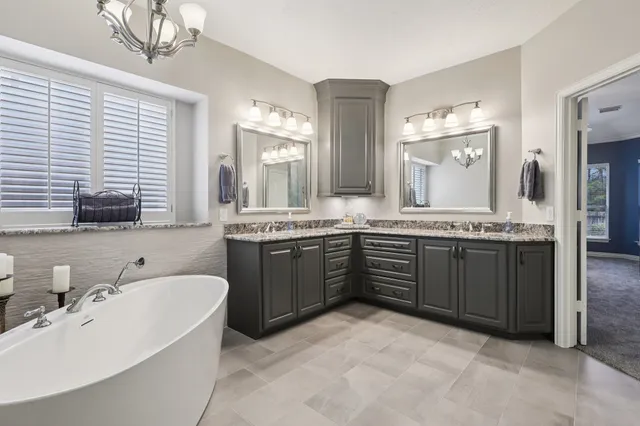 a spacious bathroom with a granite countertop sink and a bathtub