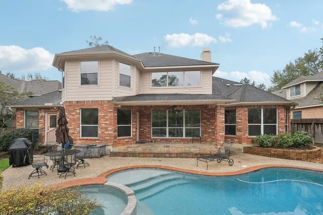 a view of a house with swimming pool and sitting area