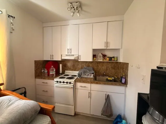 a kitchen with a stove a sink and a refrigerator