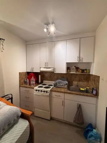 a kitchen with stainless steel appliances a sink stove and cabinets