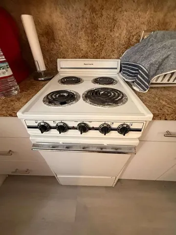 a white stove top oven sitting inside of a kitchen
