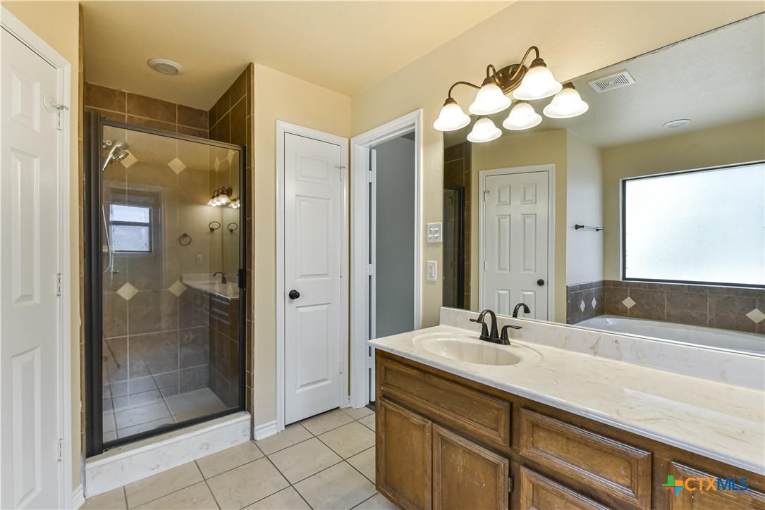 6905 Deorsam Loop Killeen, TX 76542 - Photo 17 of 21 a bathroom with a sink mirror and shower