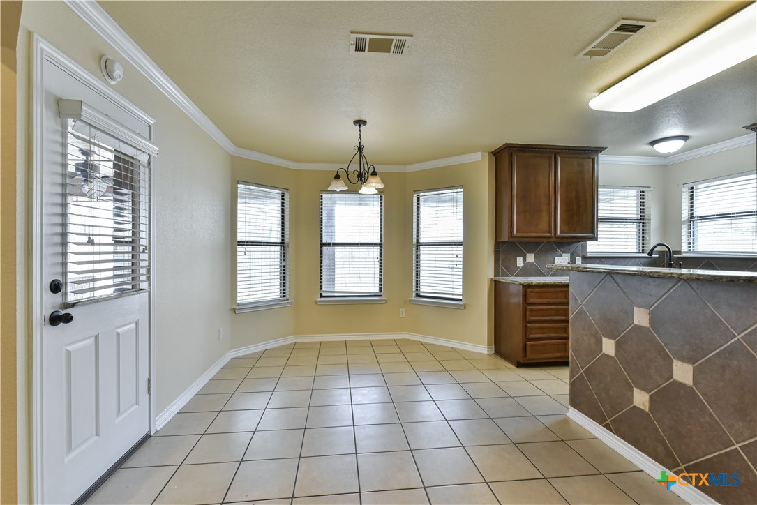6905 Deorsam Loop Killeen, TX 76542 - Photo 10 of 21 a view of a kitchen with kitchen island granite countertop cabinets and a window