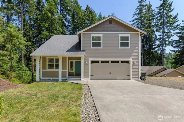 a front view of a house with yard and green space