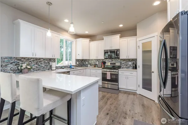 a kitchen with white cabinets and white appliances