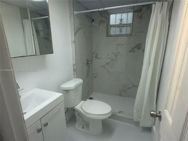 a bathroom with a toilet a sink and shower