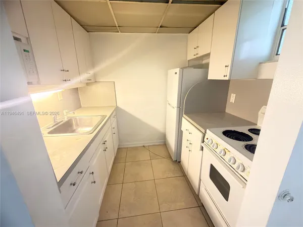 a kitchen with granite countertop a sink a stove and refrigerator