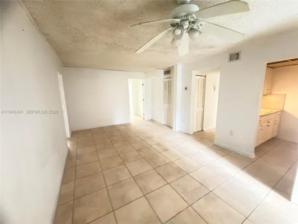 a view of a livingroom with an empty space and a ceiling fan