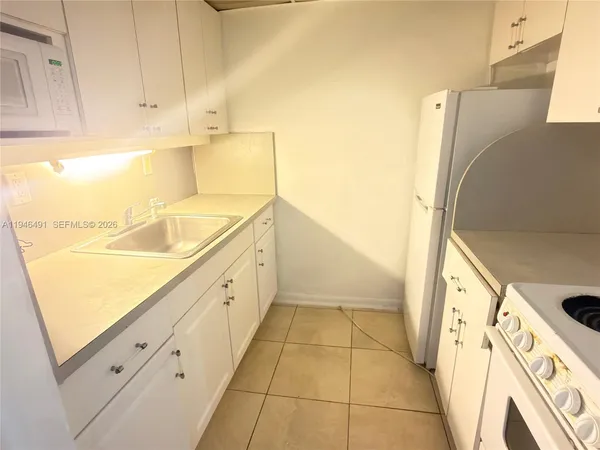 a view of a kitchen with cabinets and a refrigerator