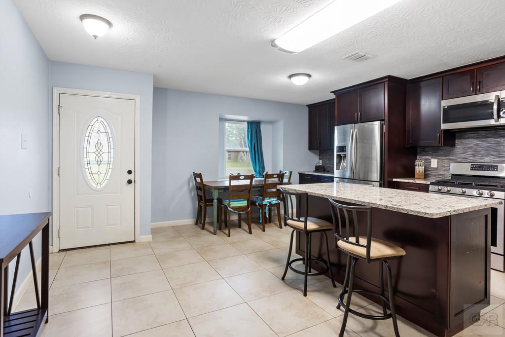 5607 Commodore Drive Dickinson, TX 77539 - Photo 9 of 23 a kitchen with stainless steel appliances granite countertop a stove refrigerator sink and cabinets