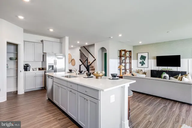 a view of a kitchen counter top space sink stainless steel appliances and wooden floor