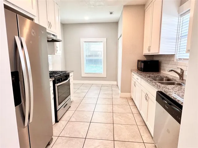 a kitchen with stainless steel appliances a stove a sink and a refrigerator