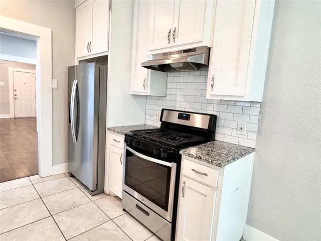 a kitchen with stainless steel appliances granite countertop a stove and a refrigerator