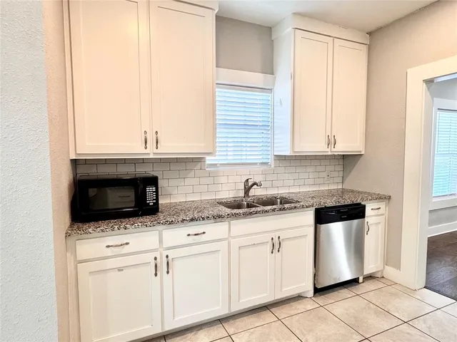 a kitchen with granite countertop white cabinets and white appliances