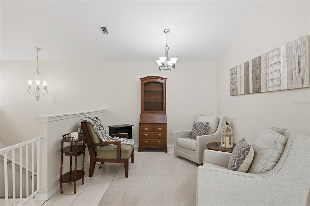 6406 Rosefinch Court, Unit 204 Lakewood Ranch, FL 34202 - Photo 11 of 36 a living room with furniture and a chandelier