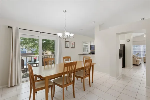 a view of a dining room and livingroom with furniture wooden floor a chandelier