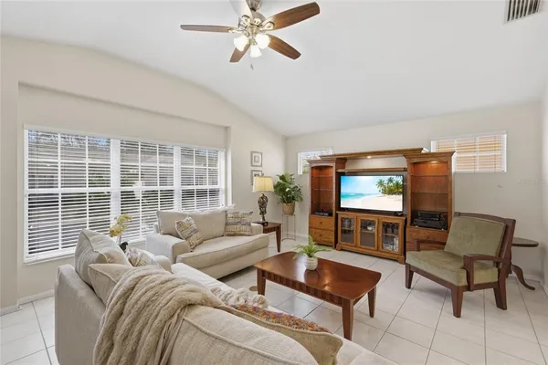 a living room with furniture a window and a flat screen tv