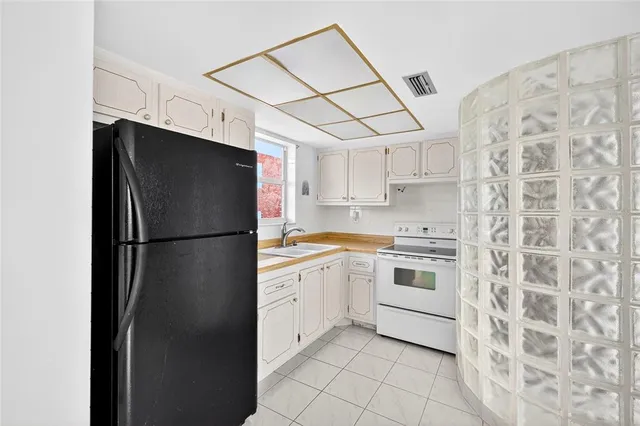 a kitchen with stainless steel appliances a refrigerator sink and cabinets
