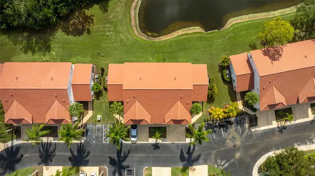 an aerial view of residential houses with outdoor space and lake view