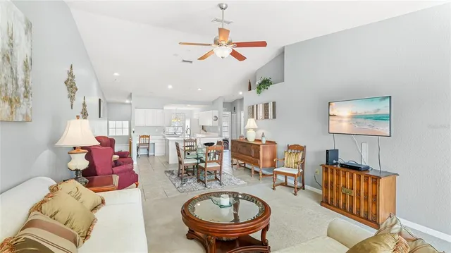 a living room with furniture kitchen view and a chandelier