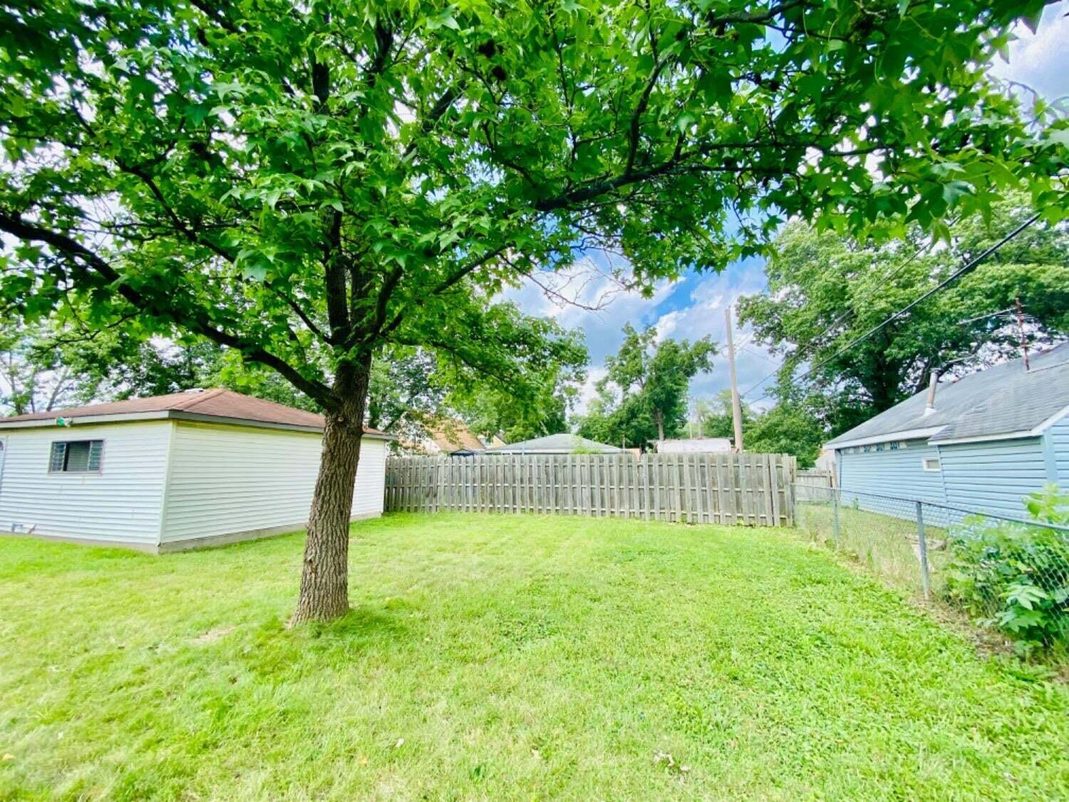 745 Juniper Road Valparaiso, IN 46385 - Photo 28 of 28 a backyard of a house with large trees and wooden fence
