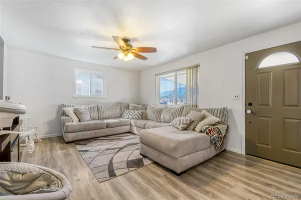 a living room with furniture and a wooden floor