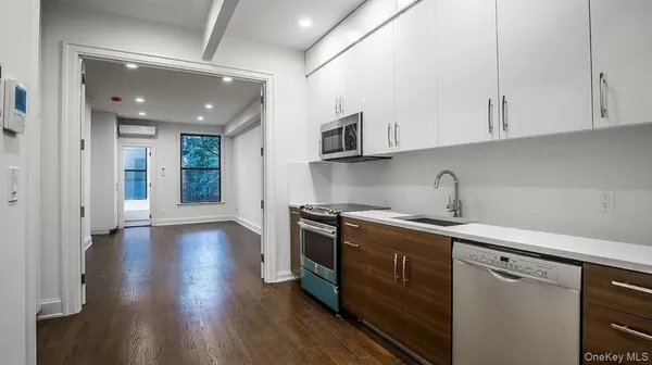 a kitchen with stainless steel appliances granite countertop a sink a stove a refrigerator and cabinets