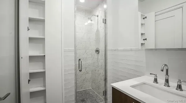 a bathroom with a sink shower and a mirror