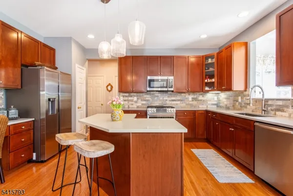 a kitchen with stainless steel appliances wooden cabinets a center island and a refrigerator