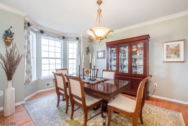a dining room with furniture a chandelier and wooden floor