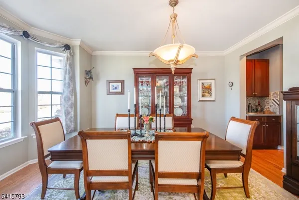 a dining room with furniture a chandelier and wooden floor