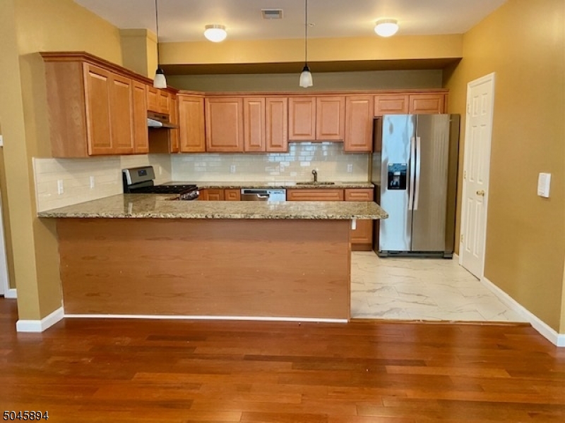 25 Cottage Street, Unit 4 Newark, NJ 07102 - Photo 2 of 13 a kitchen with stainless steel appliances granite countertop a refrigerator a stove top oven a sink and dishwasher