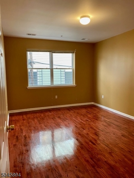 25 Cottage Street, Unit 4 Newark, NJ 07102 - Photo 7 of 13 a view of an empty room with wooden floor and a window