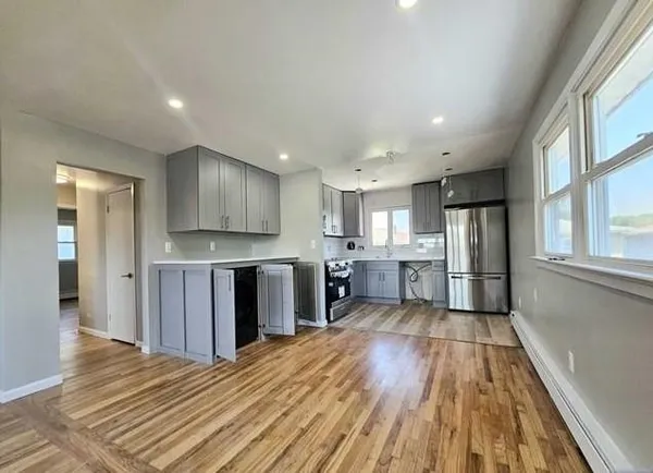 a view of kitchen with wooden floor and electronic appliances