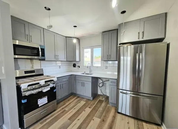a kitchen with stainless steel appliances a refrigerator sink and cabinets