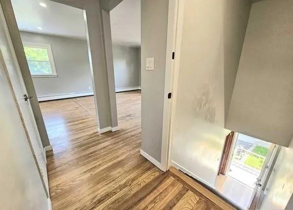 a view of a hallway with wooden floor and staircase